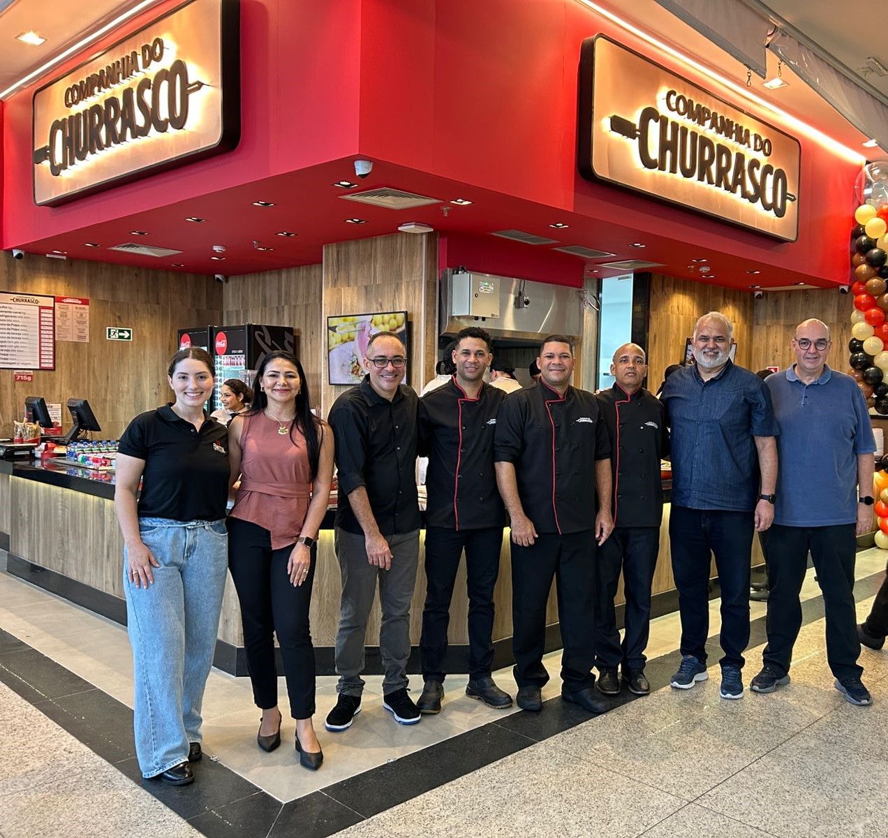 Colaboradores posam em frente à Companhia do Churrasco, na praça de alimentação do Sumaúma Park Shopping