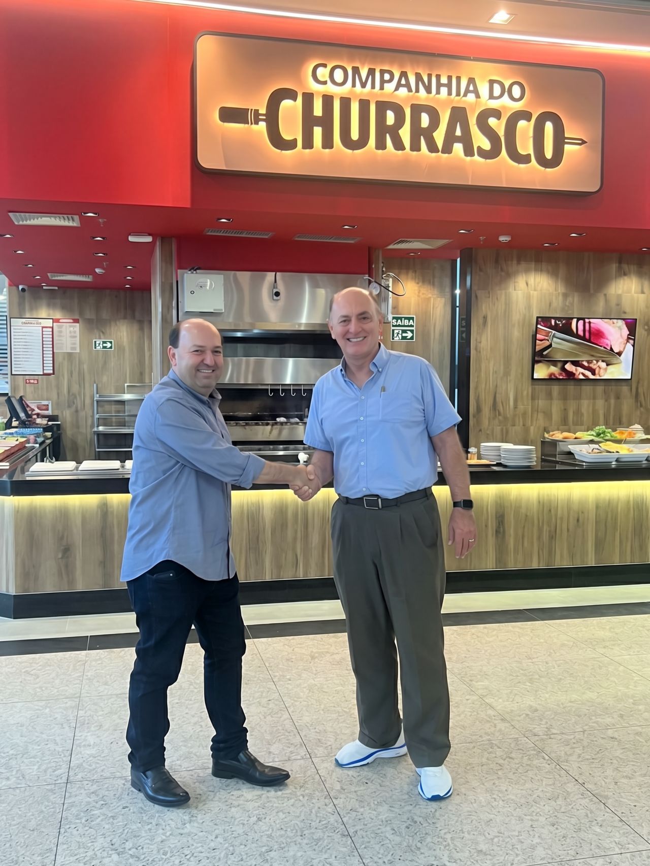 Cumprimento entre representantes da Companhia do Churrasco e do Grupo Alemã na loja do Sumaúma