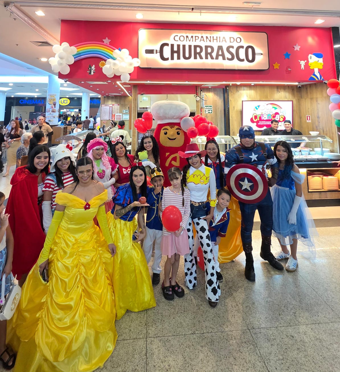 Equipe da Companhia do Churrasco com personagens fantasiados e balões no Dia das Crianças