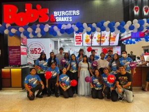 Equipe da loja Bob’s Grande Circular com camisas temáticas e balões no Dia das Crianças 2026